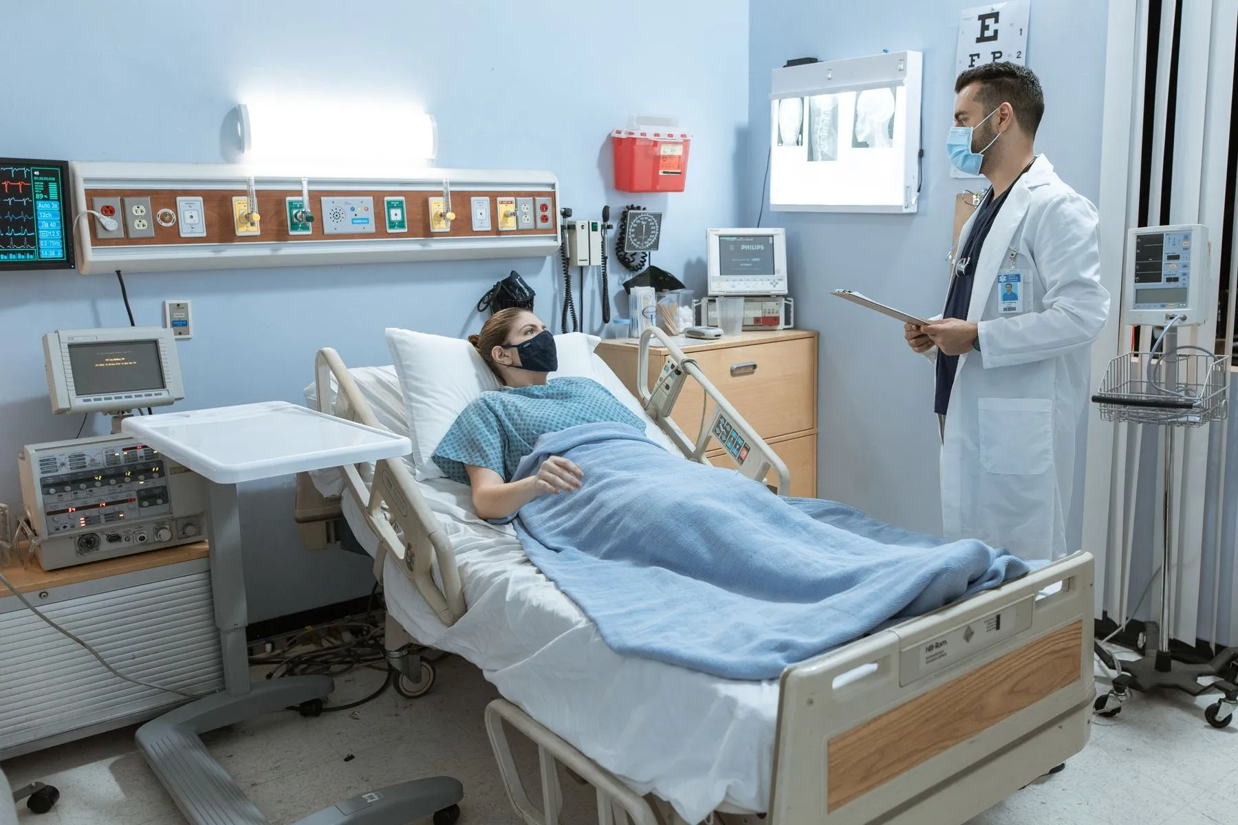 Doctor checking on a patient resting in a hospital bed