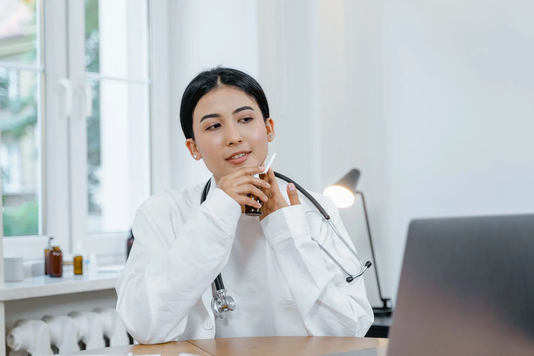 Doctor working at her desk in a bright consulting room