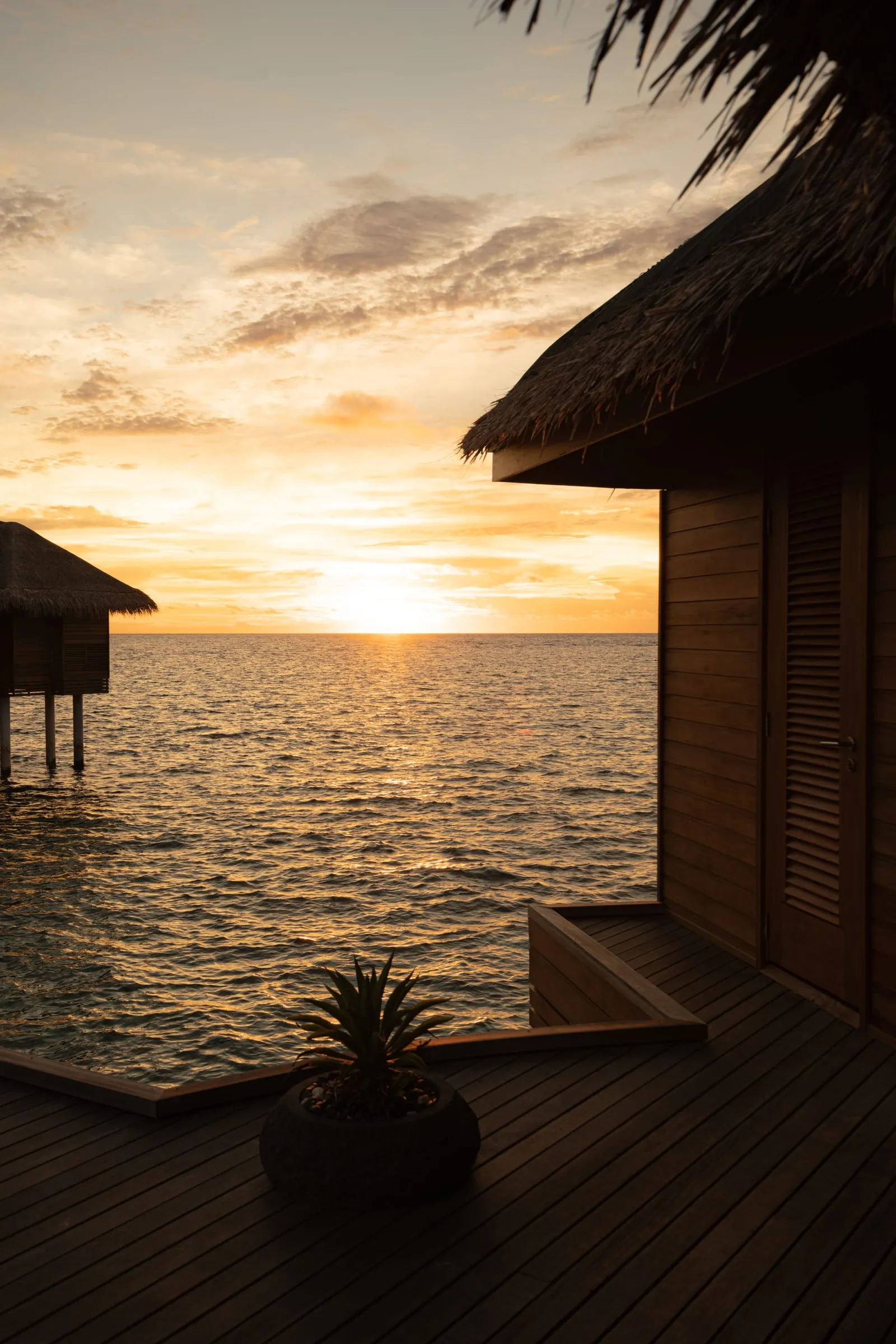 Overwater villa deck at sunset
